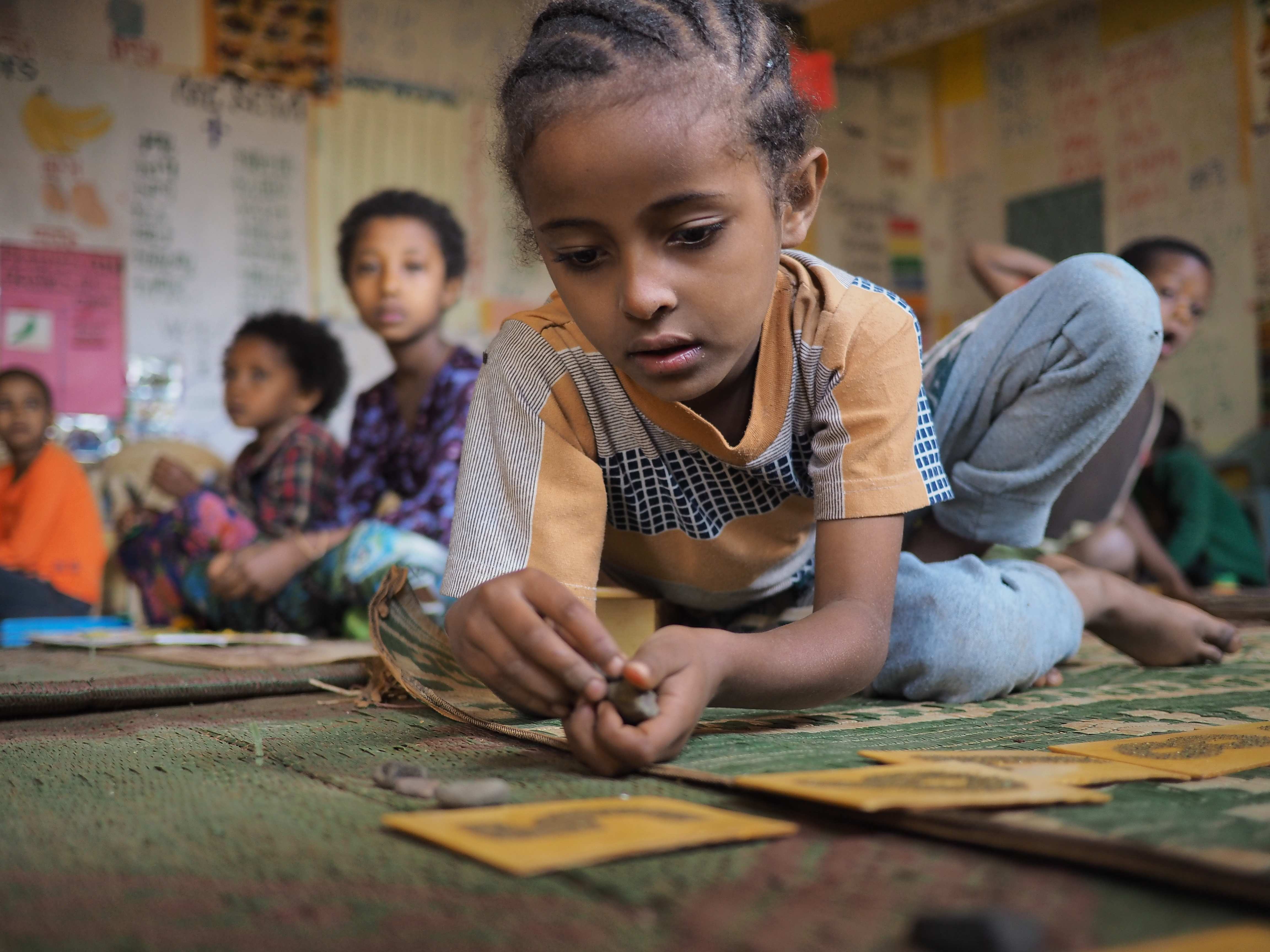 Mädchen in Äthiopien spielen auf dem Boden in einem Montessori Kindergarten. (Quelle: Malte Pfau)