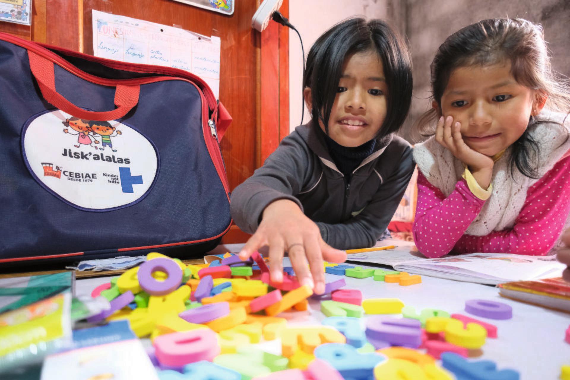 Zwei Kinder spielen mit Buchstabenmagneten (Quelle: Kindernothilfe-Partner)