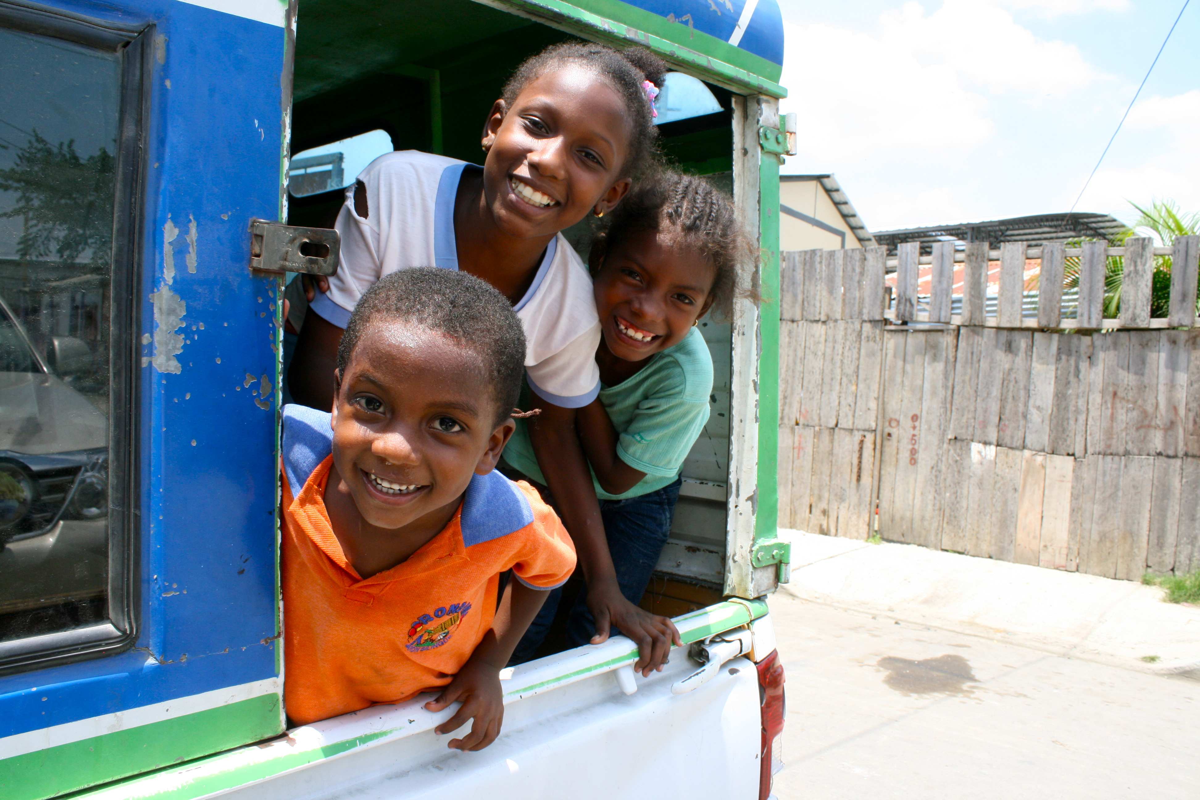 Kinder blicken lachend aus einem Busfenster (Quelle: Katrin Weidemann)