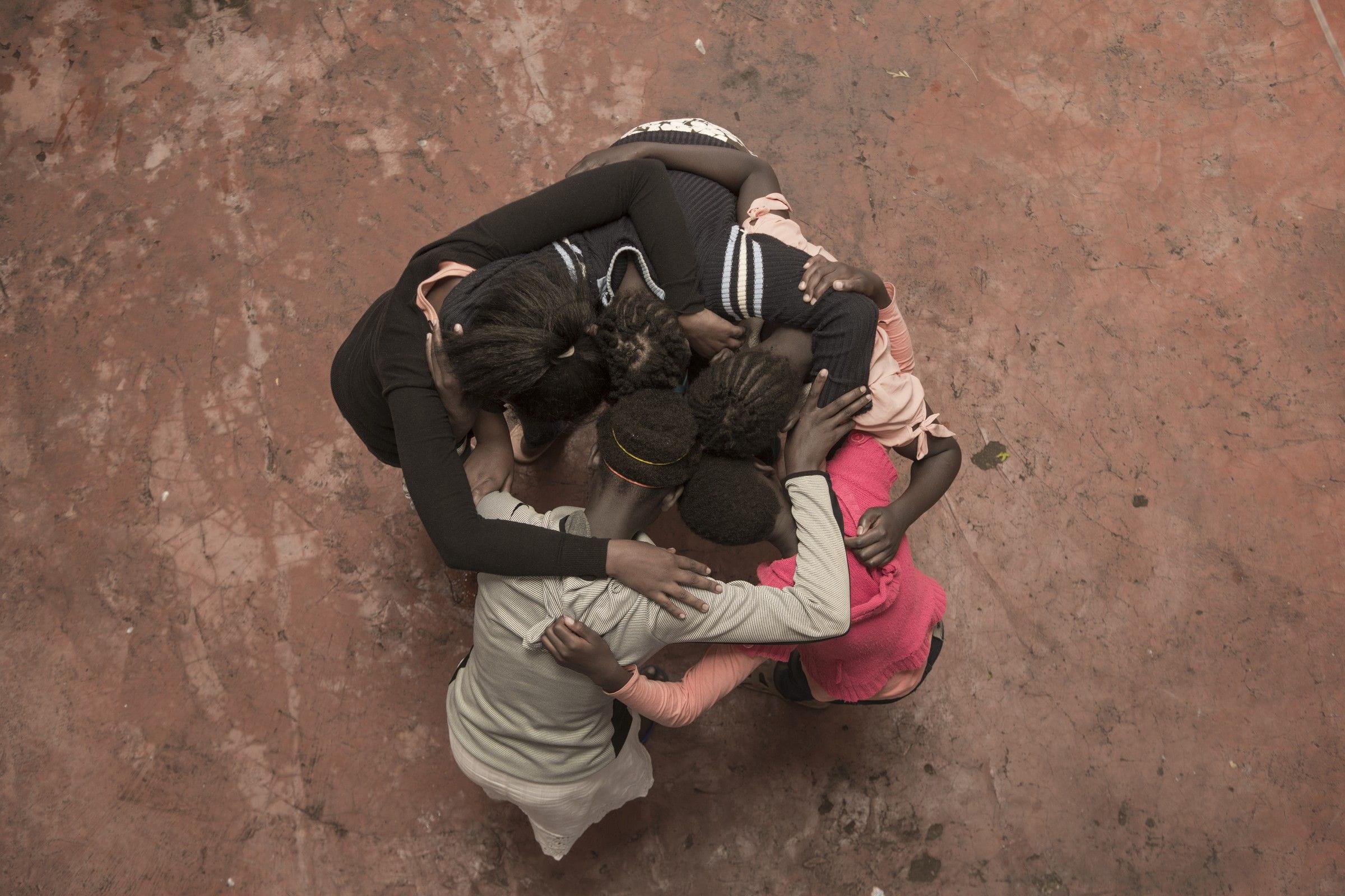 Mädchen im Tumaini Centre stehen im Kreis und umarmen sich (Bild: Christian Nusch).